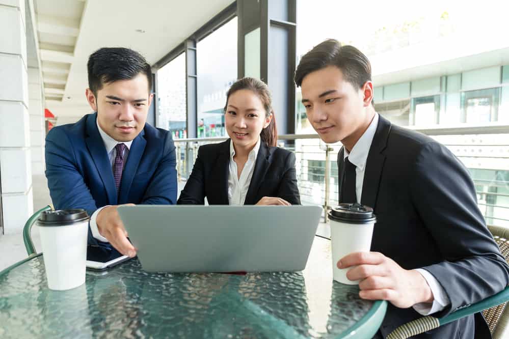 Group of business people discuss about the data showing on laptop computer
